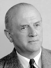 Schwarz-weißes Porträt eines mittelalten Mannes mit schütterem, zurückgekämmtem Haar